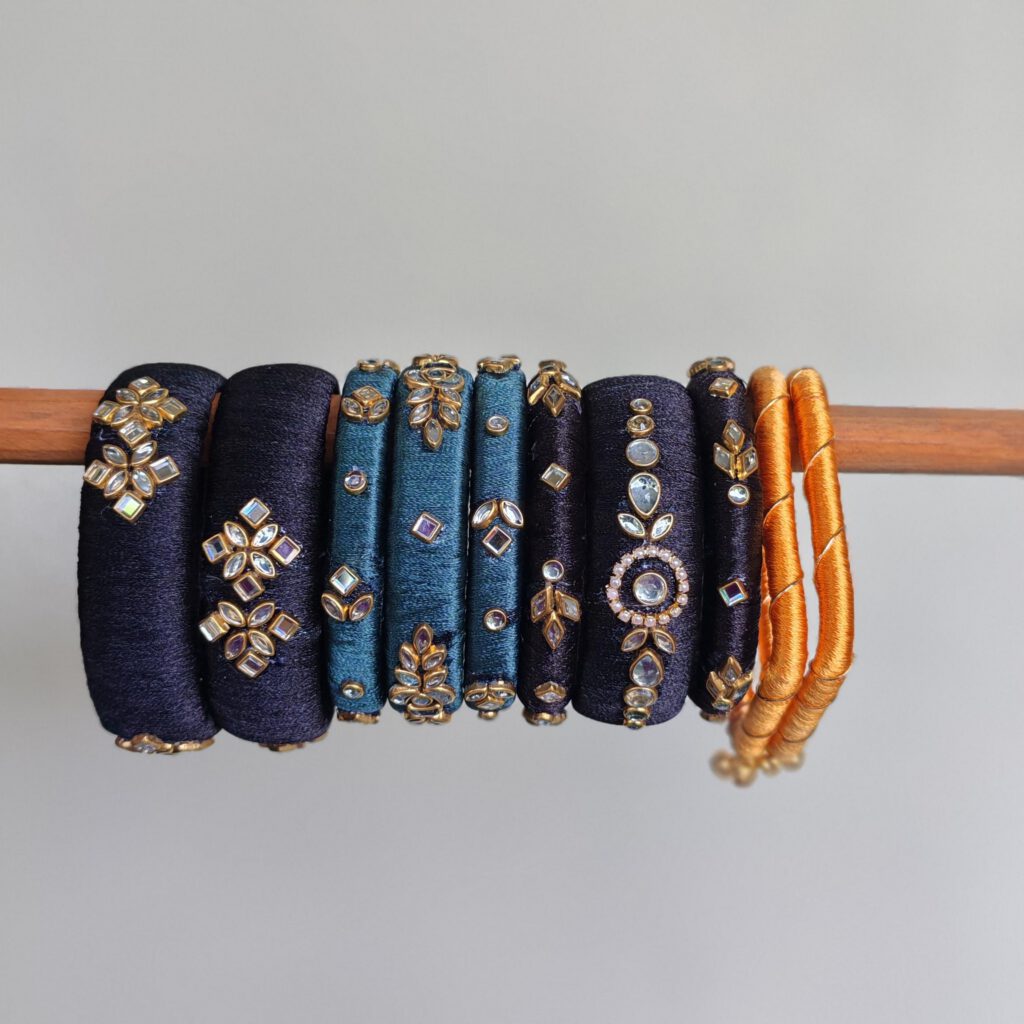 Navy, teal and mustard silk thread bangles on a stand